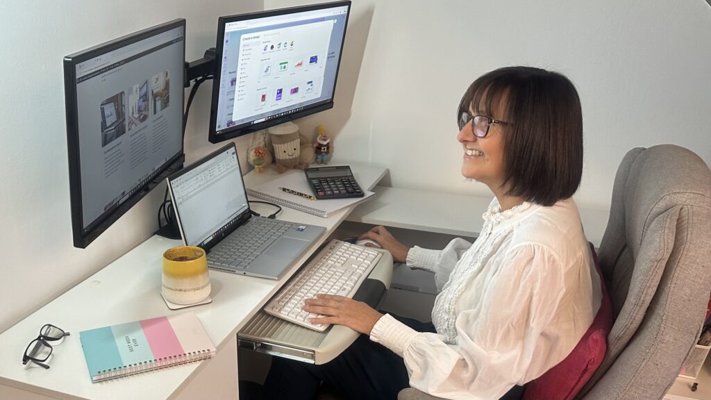 Tracey Burkinshaw Virtual Assistant working at desk with laptop, screens and keyboard